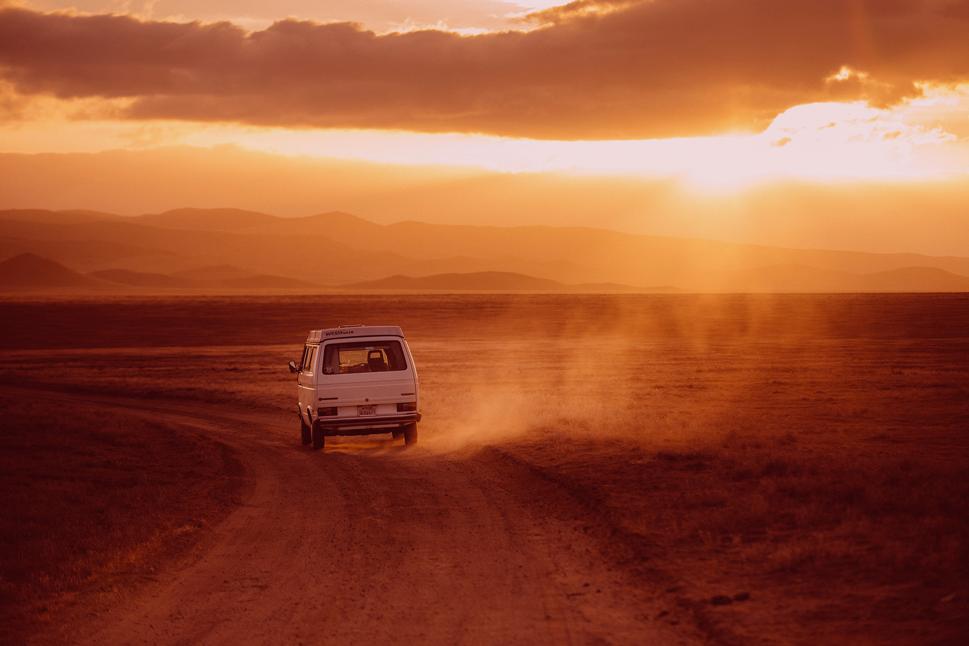 coche conduciendo por el desierto al atardecer