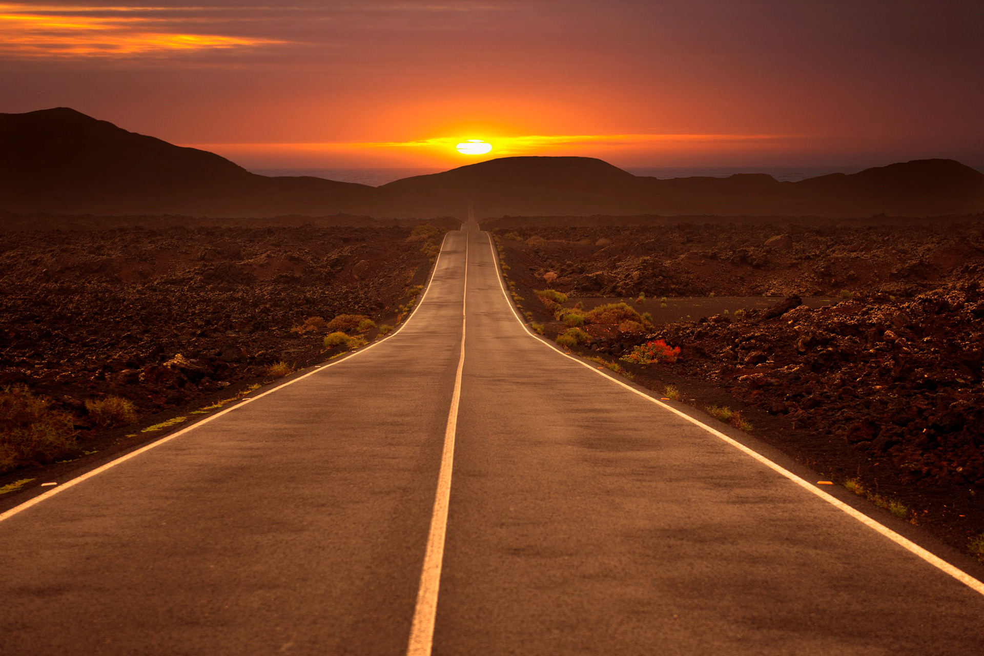 carretera que se pierde en el horizonte al atardecer